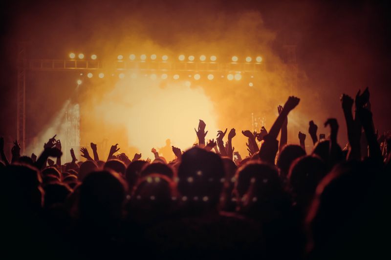 Público con las manos arriba frente al escenario